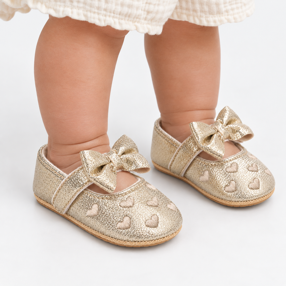 Chaussures premiers pas bébé fille dorées à nœud et cœurs brodés